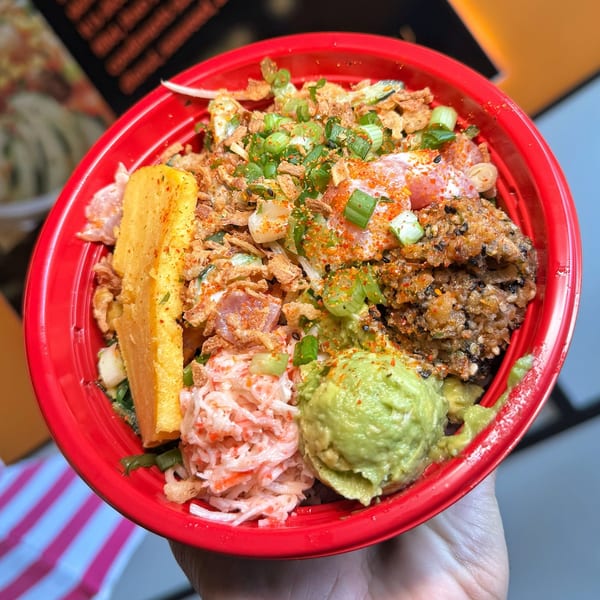 A vibrant Poke Poku bowl filled with fresh fish, avocado, crab salad, and crispy toppings.