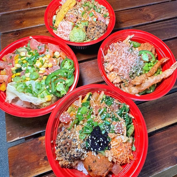 Four vibrant Poke Poku bowls filled with fresh ingredients like tuna, corn, and avocado on a wooden table.